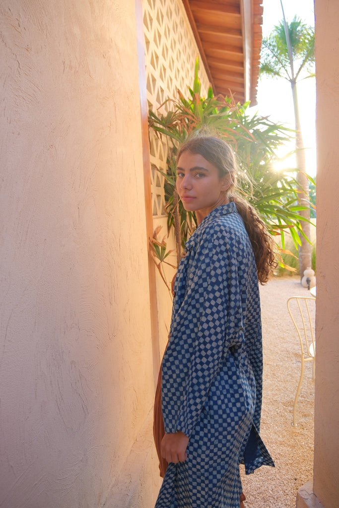 Presenting the Indigo Checkered Duster Jacket, a versatile wardrobe essential made from handwoven cotton. With its classic indigo and white checkered pattern, straight collar, coconut buttons, and relaxed fit, it’s perfect for layering over both dressy and casual outfits..