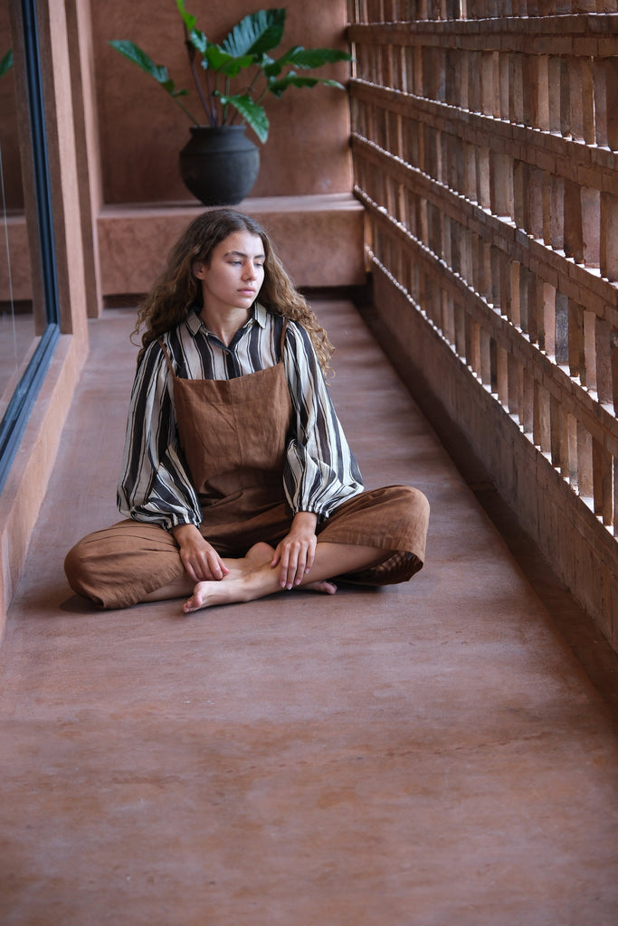 Presenting the Jane Austen Shirt from the Audrey X Crow Collection, stylishly worn by a woman in overalls. Sitting on the floor, she effortlessly highlights the shirt’s classic design and exquisite craftsmanship.