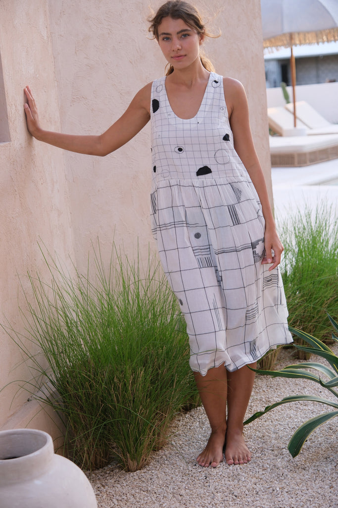 Presenting the Joan Dress, a chic collaboration between Audrey E Leary and World of Crow. This midi-length black and white dress features an elegant mosaic pattern and a round V-neck, crafted from soft, handwoven cotton with a relaxed fit, ideal for layering with the Artist Smock.