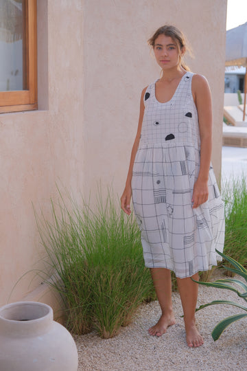 Presenting the Joan Dress, a chic collaboration between Audrey E Leary and World of Crow. This midi-length black and white dress features an elegant mosaic pattern and a round V-neck, crafted from soft, handwoven cotton with a relaxed fit, ideal for layering with the Artist Smock.