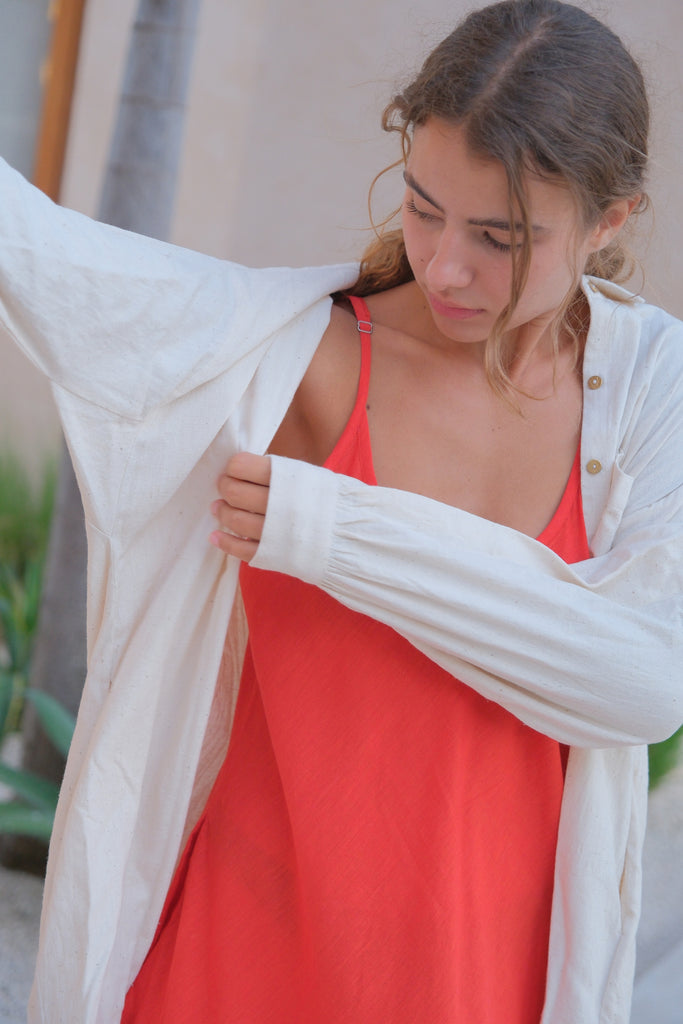 Presenting the White Artist Smock, a collaboration between Audrey E Leary and World of Crow. Made from thick, handwoven organic cotton, this short smock features a straight collar, puffed full sleeves, and gathered cuffs, with spacious pockets and a comfortable fit ideal for painting, crafting, and travel.